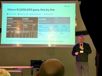 A speaker presents a budget breakdown for TYPO3, detailing allocations for innovation, product development, and community projects, with figures displayed on a screen.