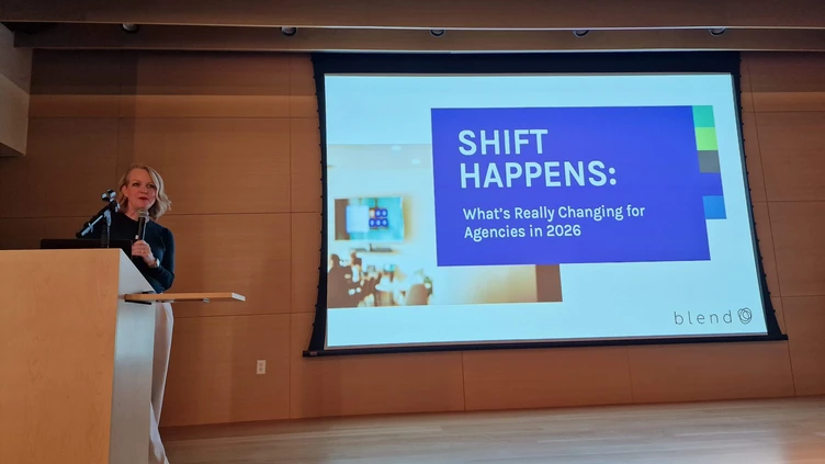 Ein Referent präsentiert auf einer Konferenz eine Diashow mit dem Titel „SHIFT HAPPENS: Was sich 2026 wirklich für Agenturen ändert“.