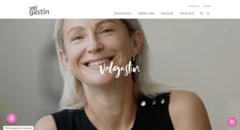 Smiling woman with light hair wearing a black top, featured prominently on a website with the text "Velgastin" displayed.