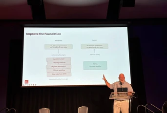 Ein Referent präsentiert Informationen zur mehrsprachigen Governance und Softwareverbesserungen, mit einer Folie, die die wichtigsten Punkte zu WordPress und TYPO3 umreißt.