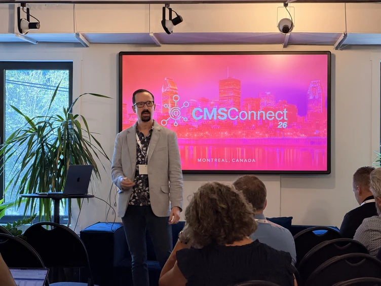A speaker presents at CMSConnect 26 in Montreal, Canada, with a colorful backdrop displaying the event's logo and city skyline.