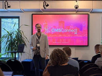 A speaker presents at CMSConnect 26 in Montreal, Canada, with a colorful backdrop displaying the event logo and city skyline.