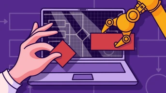 A robotic arm is positioned near a laptop screen displaying a grid and technical diagrams, while a human hand holds a red block, suggesting interaction between technology and manual input.